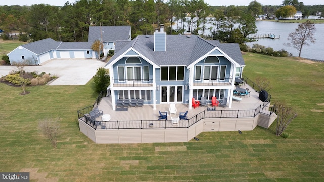 back of property with a deck with water view, a patio area, an outdoor living space, a balcony, and a lawn