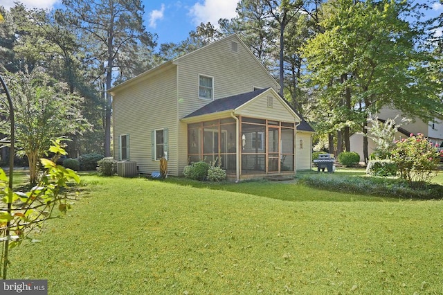 rear view of property with a sunroom, central AC, and a lawn