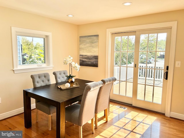 dining space with light hardwood / wood-style flooring and plenty of natural light