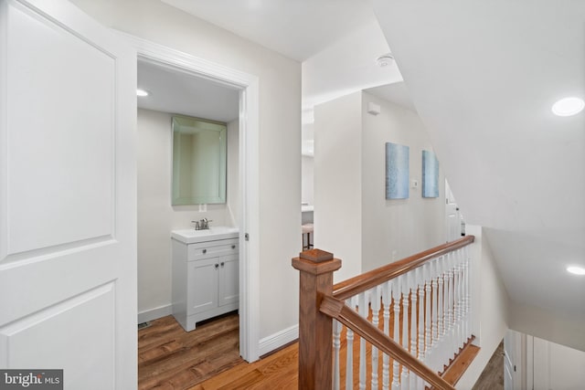 hall with sink and light wood-type flooring