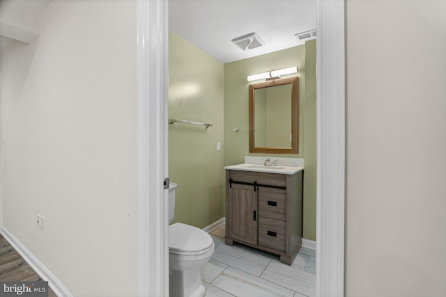 bathroom featuring vanity, toilet, and wood-type flooring