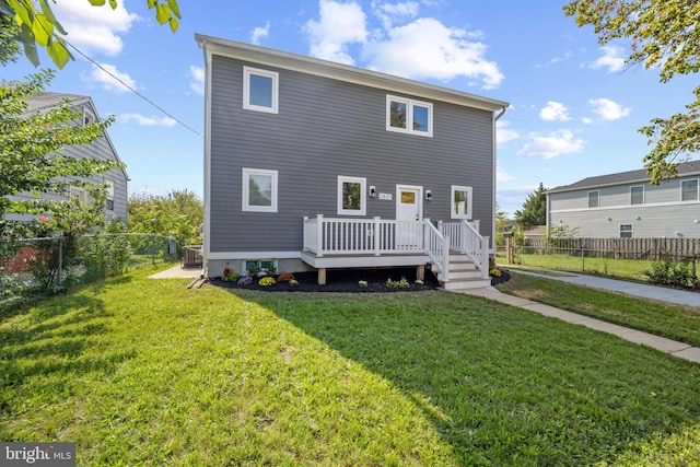 back of house featuring a yard, a wooden deck, and central air condition unit