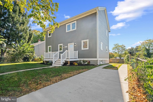 view of front of home featuring a front yard and a wooden deck