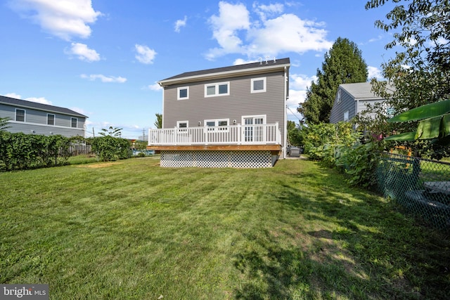 rear view of property with a deck and a yard