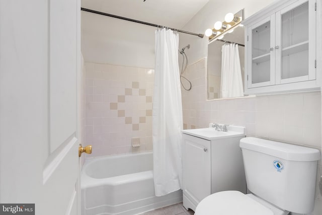 full bathroom featuring vanity, backsplash, toilet, tile walls, and shower / tub combo