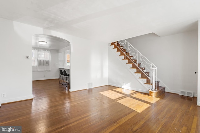 unfurnished living room with dark wood-type flooring