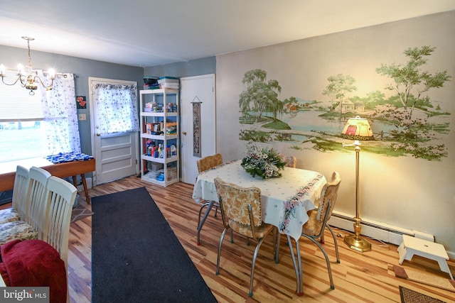 dining area featuring hardwood / wood-style floors, baseboard heating, and an inviting chandelier