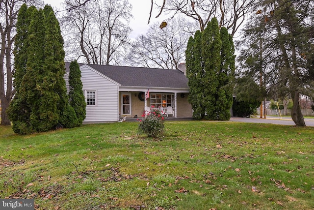 ranch-style home featuring a porch and a front lawn