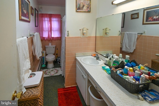 bathroom with vanity, toilet, and tile walls