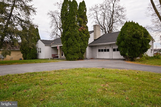 view of front of home with a garage and a front lawn