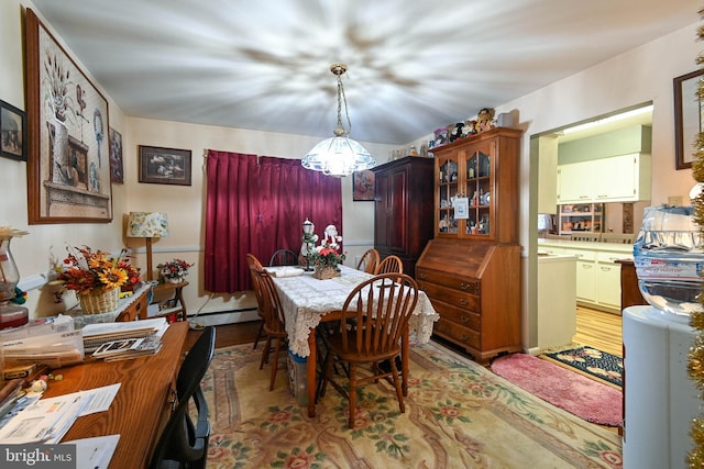 dining room featuring an inviting chandelier, light hardwood / wood-style flooring, and a baseboard heating unit