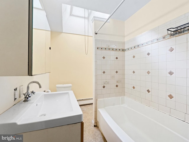 full bathroom featuring a skylight, a baseboard heating unit, toilet, tiled shower / bath, and vanity