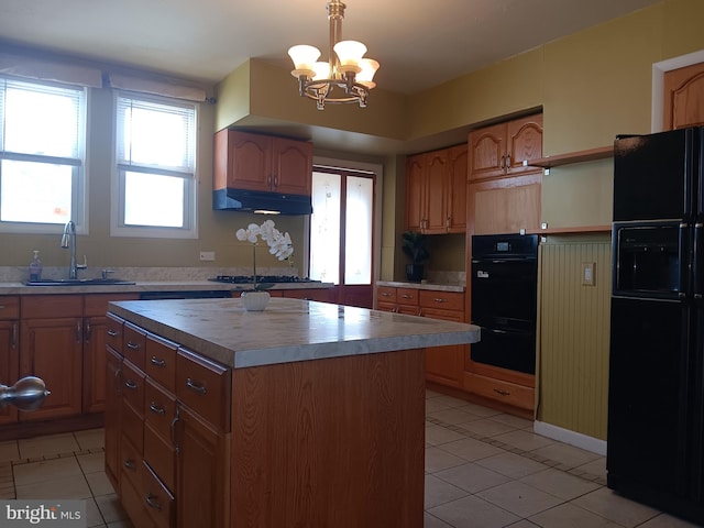 kitchen with black appliances, sink, a center island, pendant lighting, and a chandelier