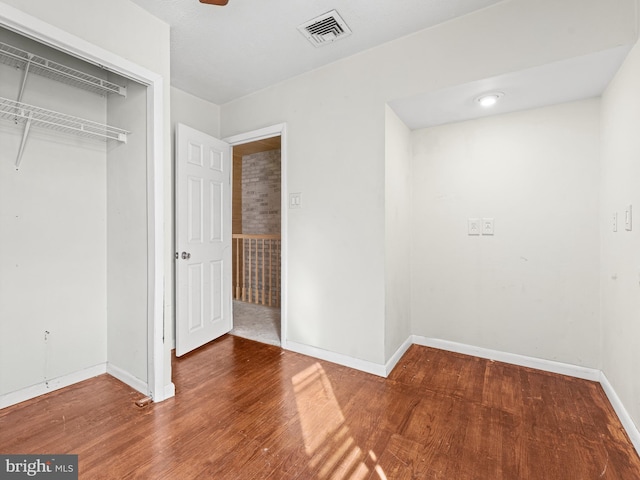 unfurnished bedroom featuring hardwood / wood-style floors and a closet