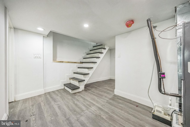 finished basement with baseboards, wood finished floors, stairs, and recessed lighting