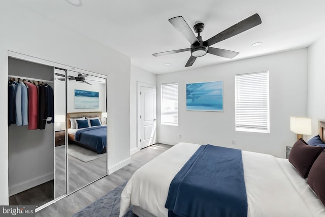 bedroom with a closet, hardwood / wood-style flooring, and ceiling fan