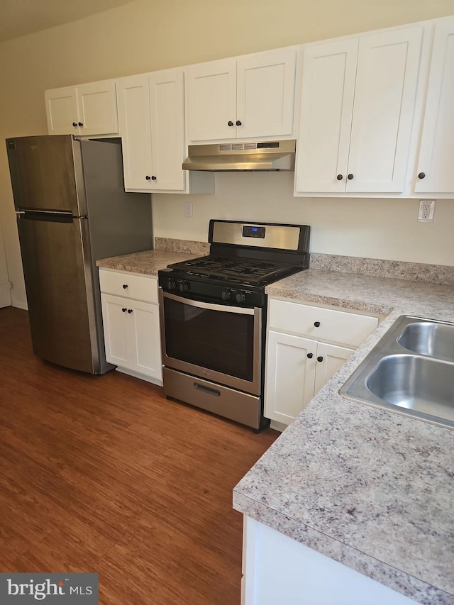 kitchen featuring sink, dark hardwood / wood-style flooring, white cabinets, and appliances with stainless steel finishes