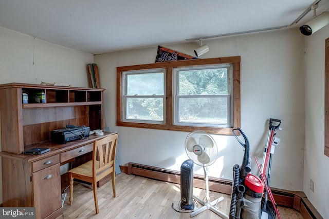 home office with light hardwood / wood-style floors and baseboard heating