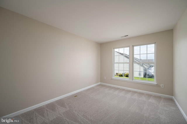 spare room featuring light colored carpet