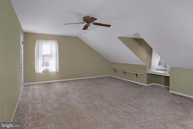 additional living space featuring vaulted ceiling, light colored carpet, and ceiling fan