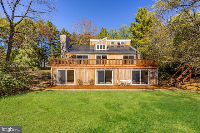 rear view of property featuring a deck and a yard