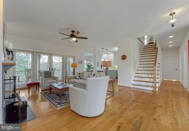 living room featuring ceiling fan, light wood-type flooring, and french doors