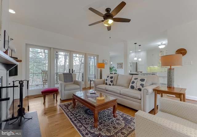 living room with ceiling fan and light wood-type flooring