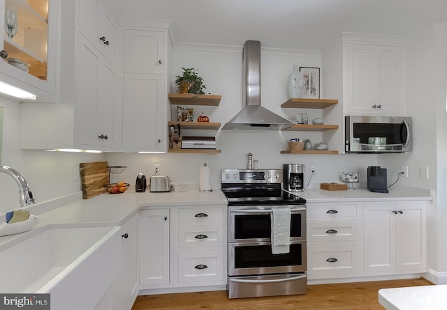 kitchen with white cabinets, stainless steel appliances, and extractor fan