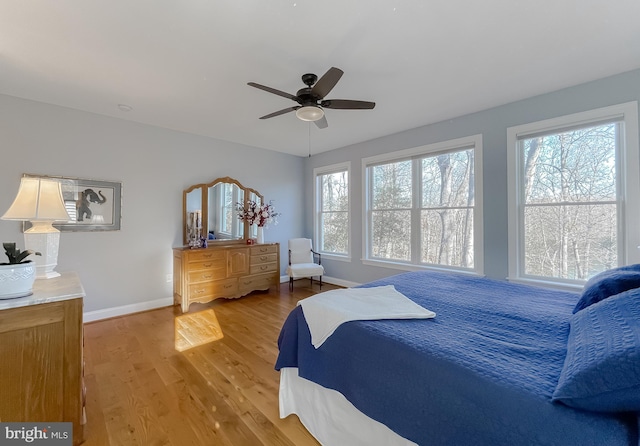 bedroom featuring hardwood / wood-style floors, multiple windows, and ceiling fan