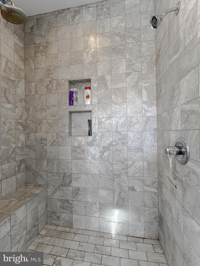 bathroom with tile patterned flooring and a tile shower