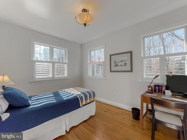 bedroom with hardwood / wood-style flooring and multiple windows