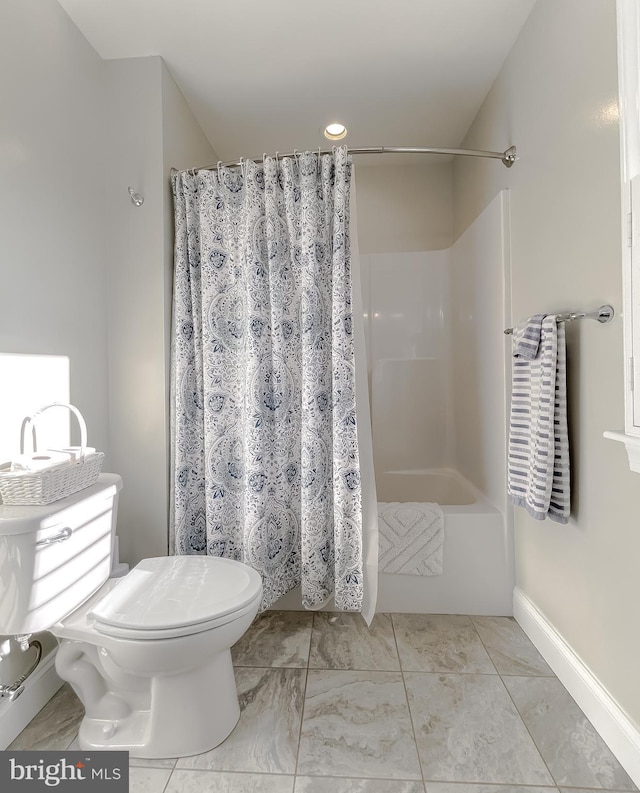 bathroom featuring toilet and curtained shower