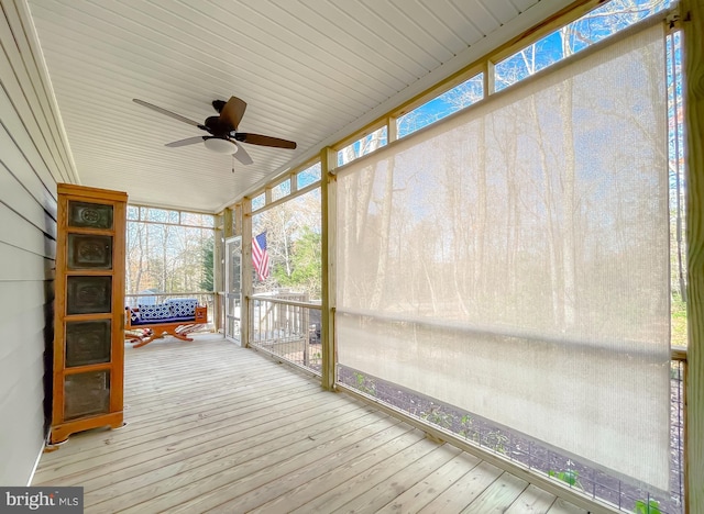 unfurnished sunroom with ceiling fan