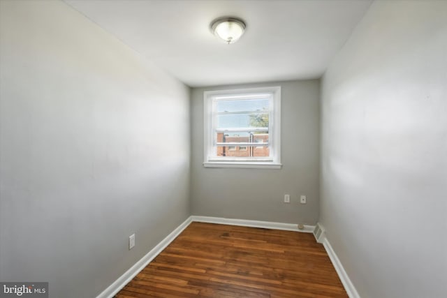 unfurnished room with dark wood-type flooring