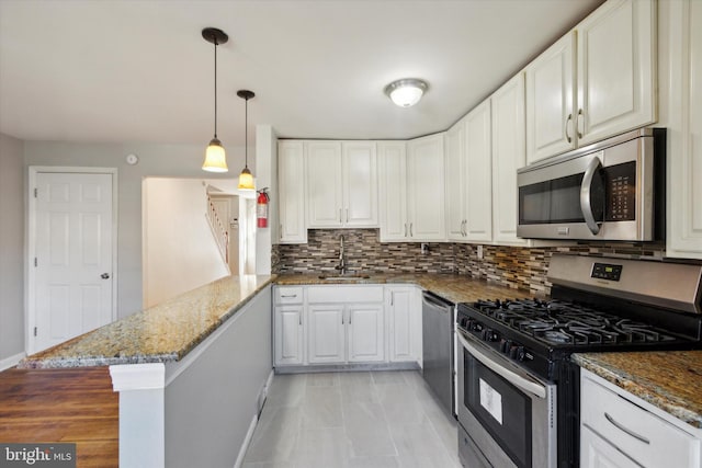 kitchen featuring kitchen peninsula, white cabinetry, sink, and stainless steel appliances