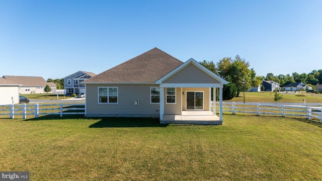 rear view of house featuring a patio and a yard