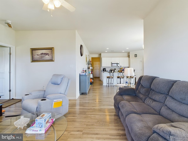 living room featuring ceiling fan and light hardwood / wood-style flooring