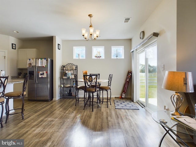 dining area with an inviting chandelier and dark hardwood / wood-style flooring