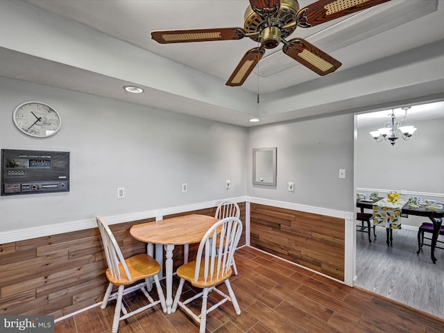 dining area featuring wood-type flooring and ceiling fan with notable chandelier