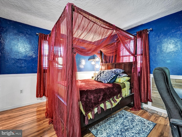 bedroom featuring wood-type flooring and a textured ceiling