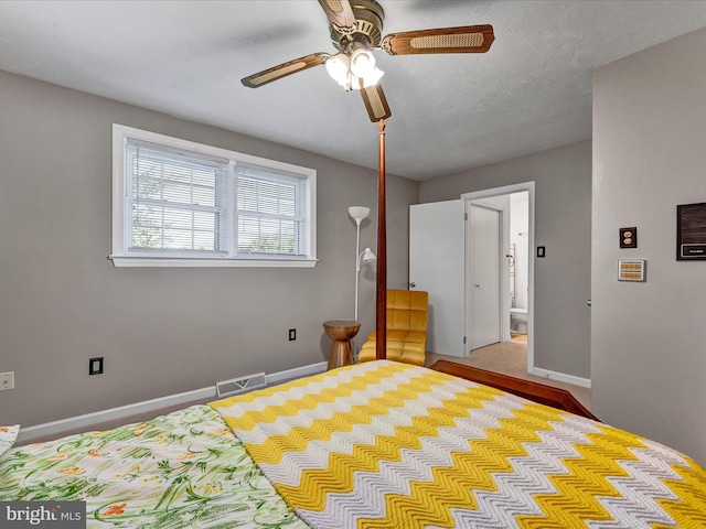 bedroom featuring ensuite bath, a textured ceiling, and ceiling fan