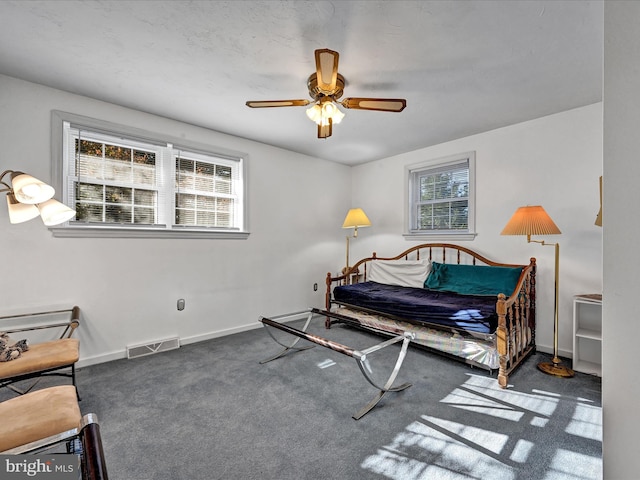 carpeted bedroom with multiple windows and ceiling fan