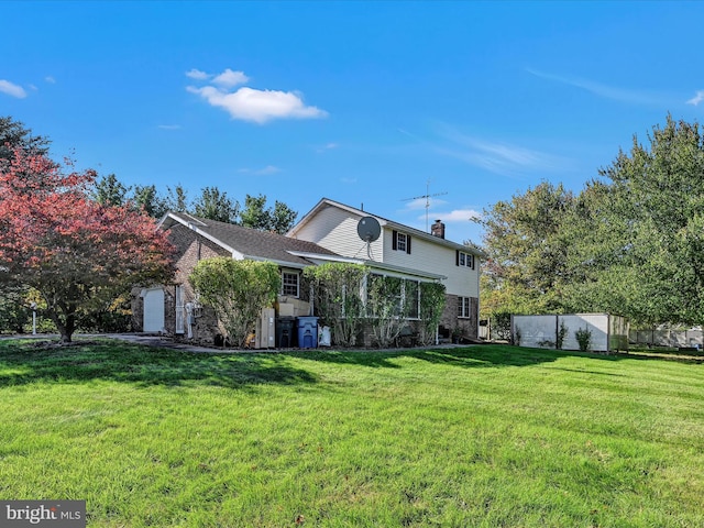 rear view of property featuring a yard and a garage