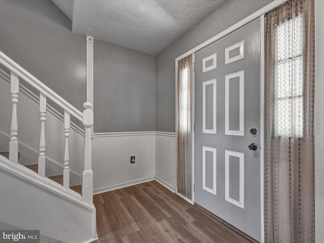 entrance foyer featuring a textured ceiling and wood-type flooring