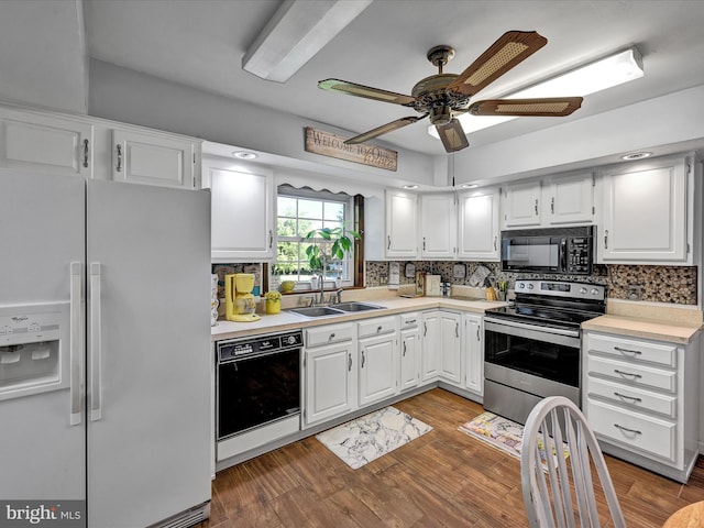 kitchen featuring wood-type flooring, backsplash, sink, black appliances, and white cabinets