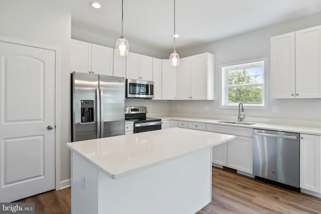 kitchen featuring stainless steel appliances, white cabinetry, and a center island