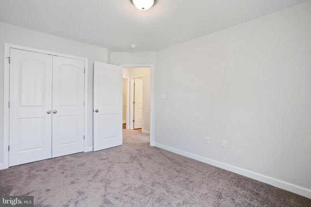 unfurnished bedroom featuring a closet and light carpet