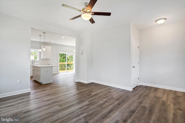 unfurnished living room with ceiling fan and dark hardwood / wood-style floors