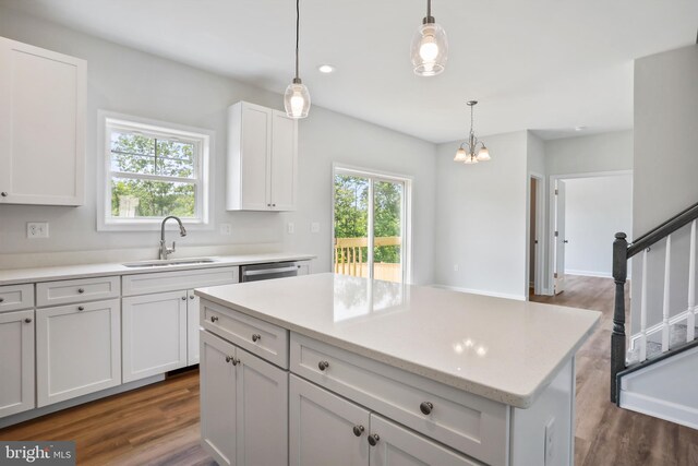 kitchen featuring sink, white cabinetry, dark hardwood / wood-style floors, a kitchen island, and pendant lighting