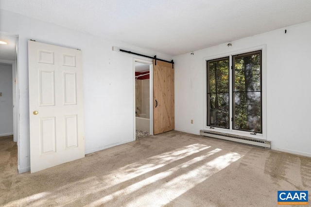 unfurnished bedroom featuring light colored carpet, connected bathroom, a barn door, and a baseboard heating unit